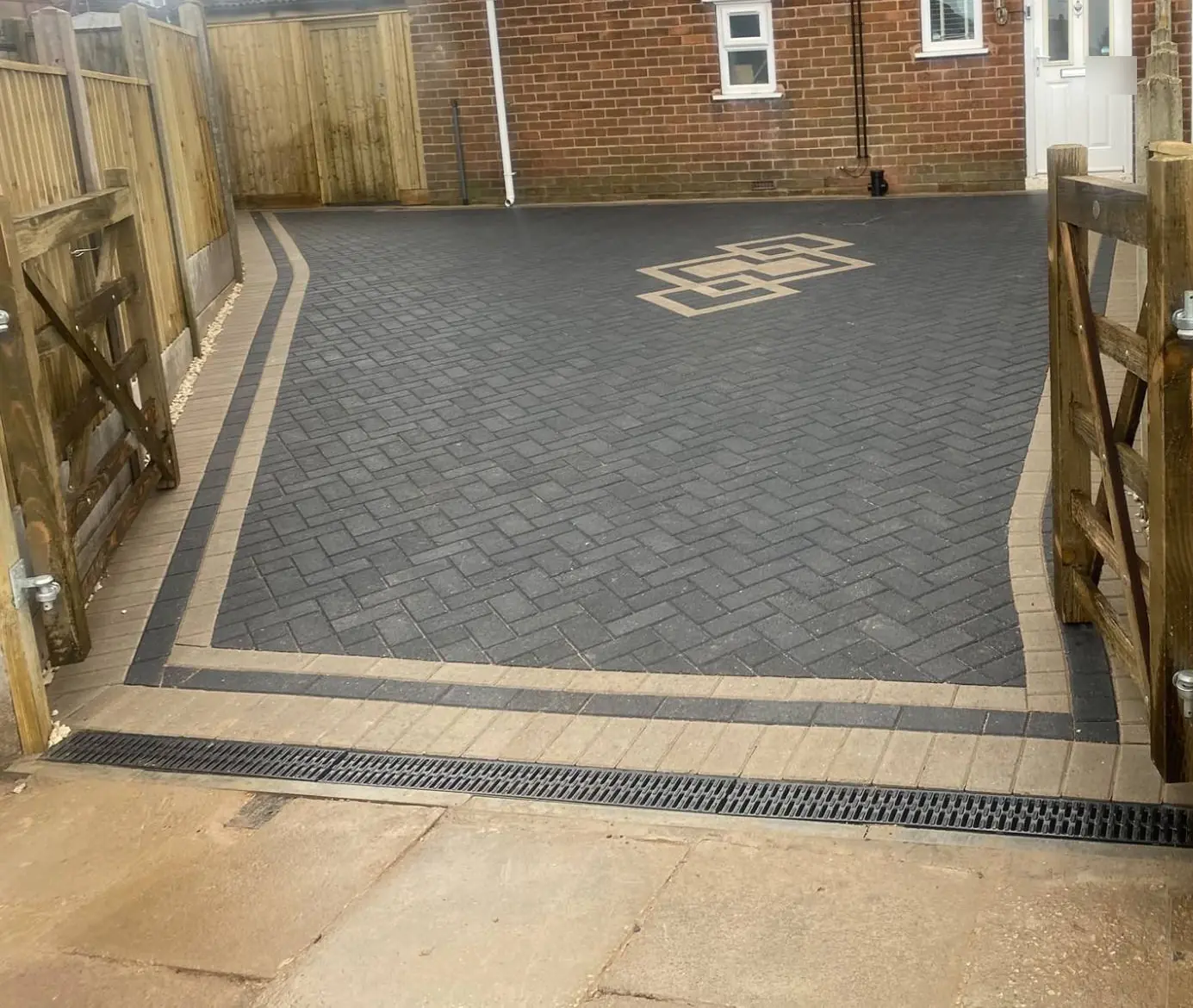 Charcoal herringbone block paving with a double buff and charcoal border, buff inlay and a channel drain on an Ashfield driveway near Mansfield