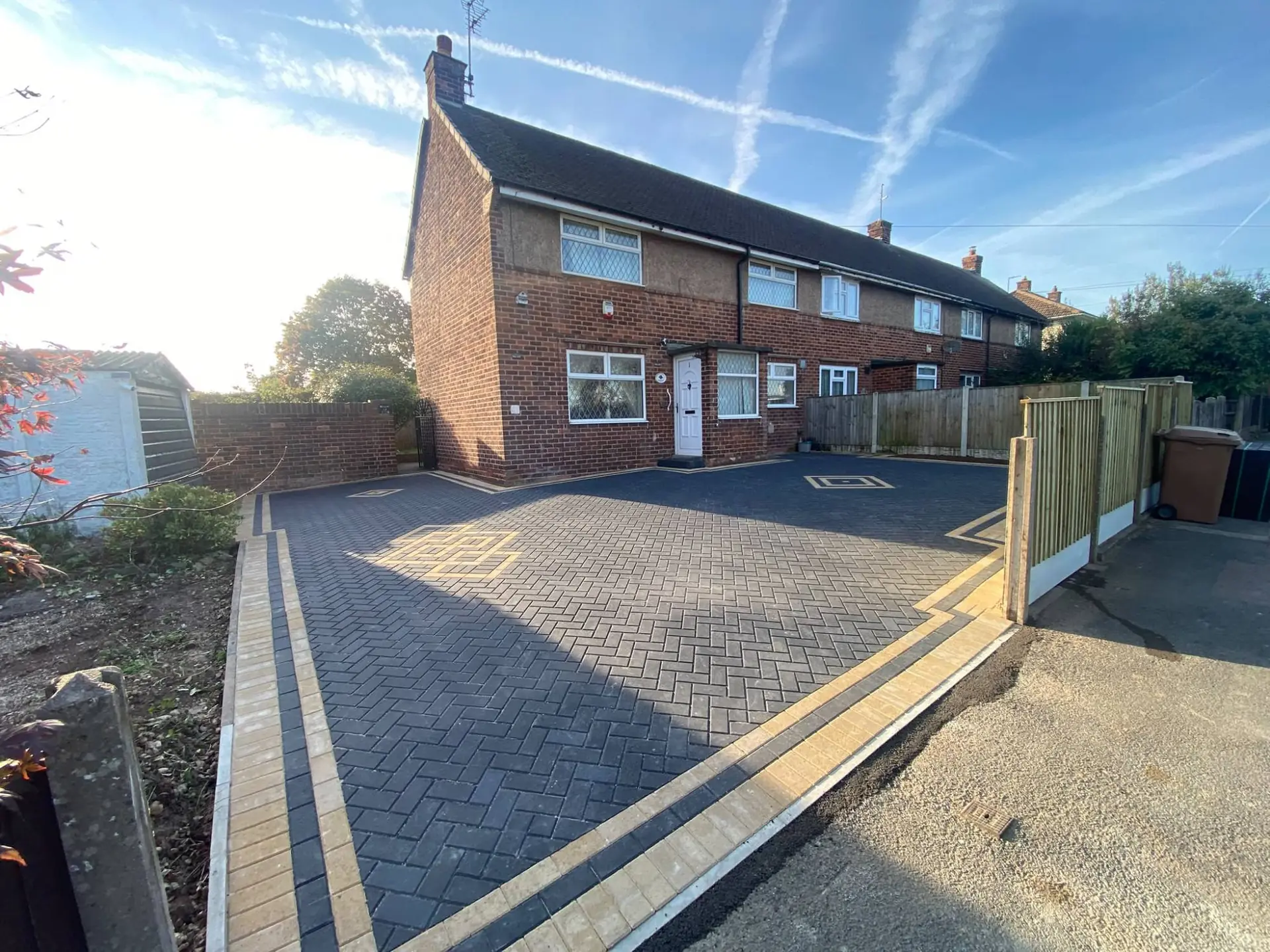 Charcoal herringbone block paving with a buff border and yellow inlay motifs on a Ladybrook driveway in Mansfield