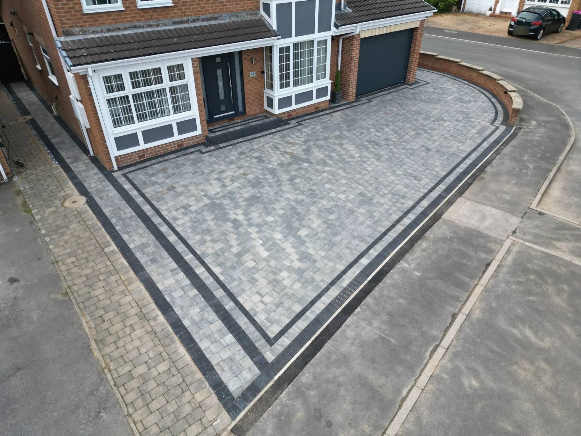 Drone view of the new slate grey block driveway with a double charcoal border at the front of a house in Todwick