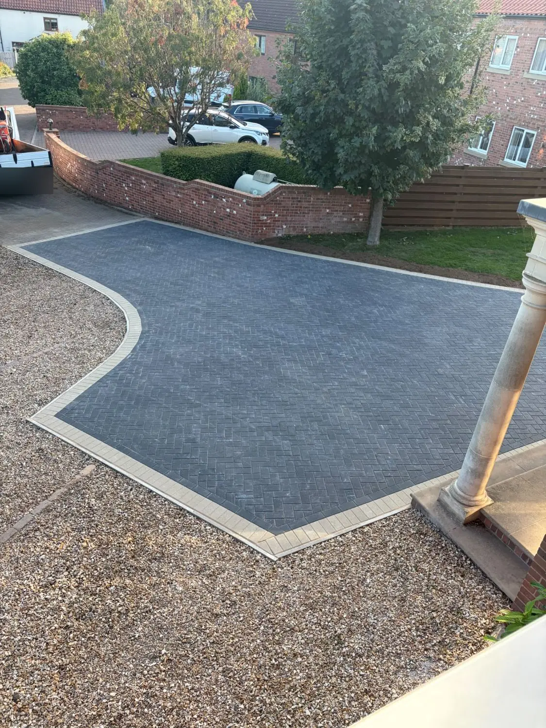 Charcoal herringbone block paving with a buff border, seen from above, on a Tuxford driveway