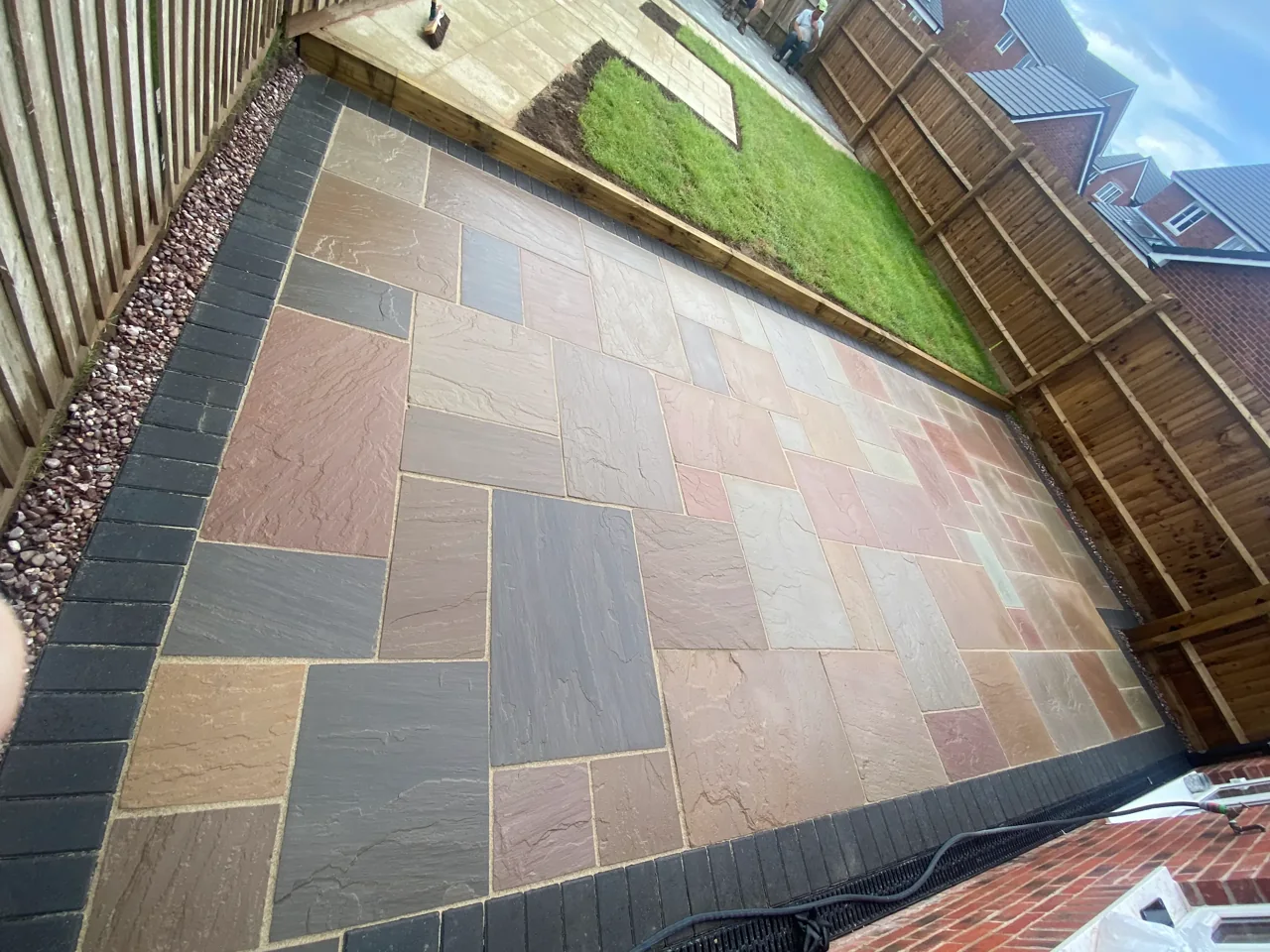 Multi-tone sandstone patio with a charcoal block border