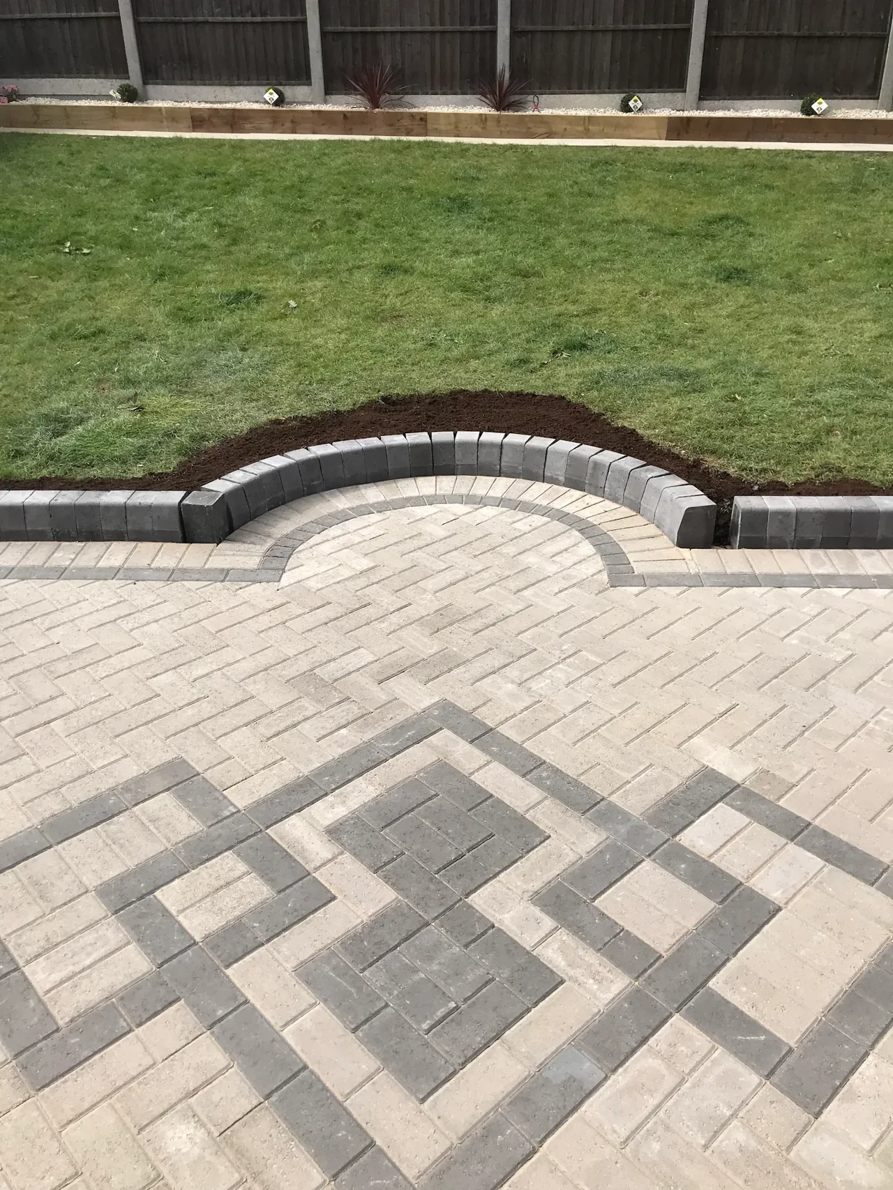 Block paving with a contrasting pattern and curved border step