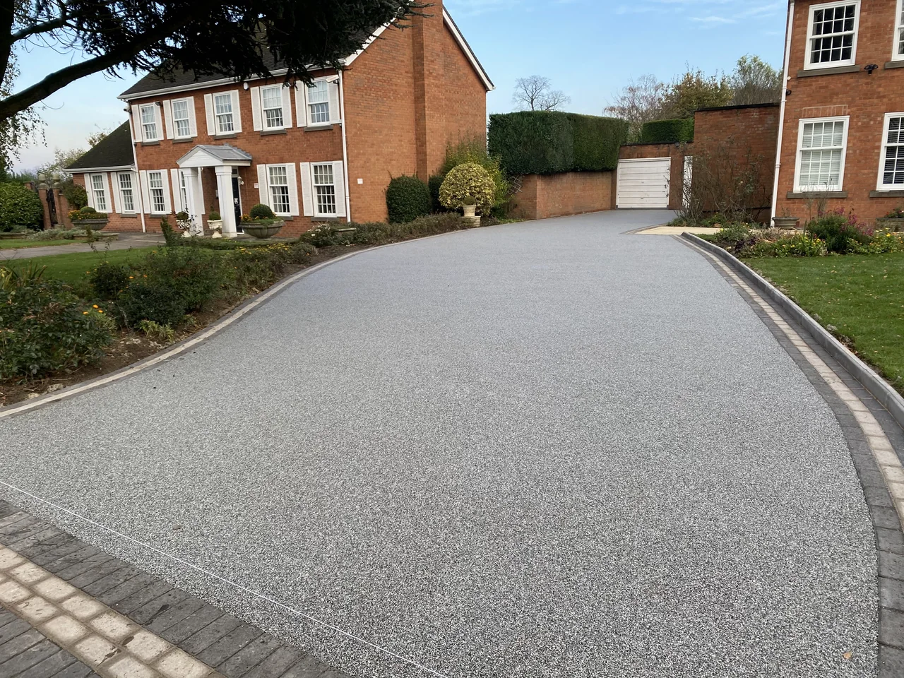 Long curved resin driveway with block edging