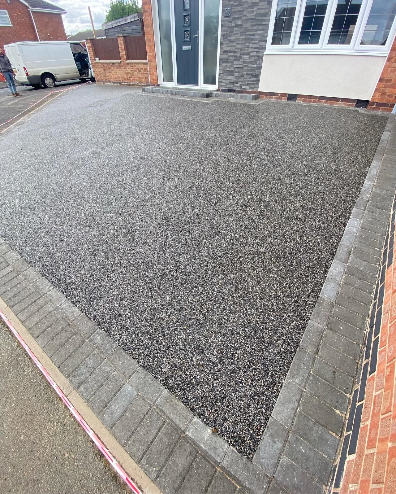 Dark aggregate driveway with a red block edge