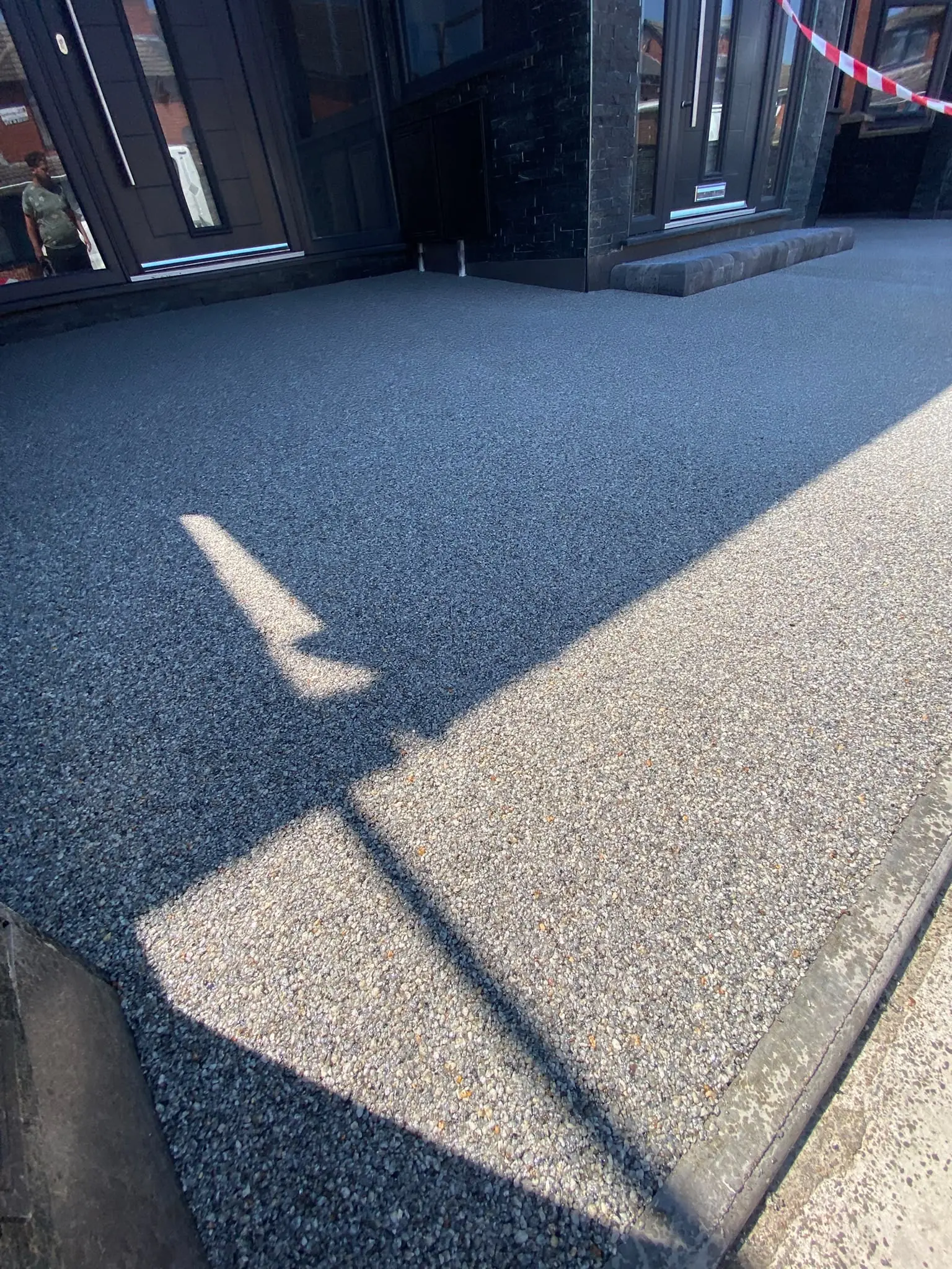Dark grey resin bound surface freshly laid beside the front door of a Mansfield house