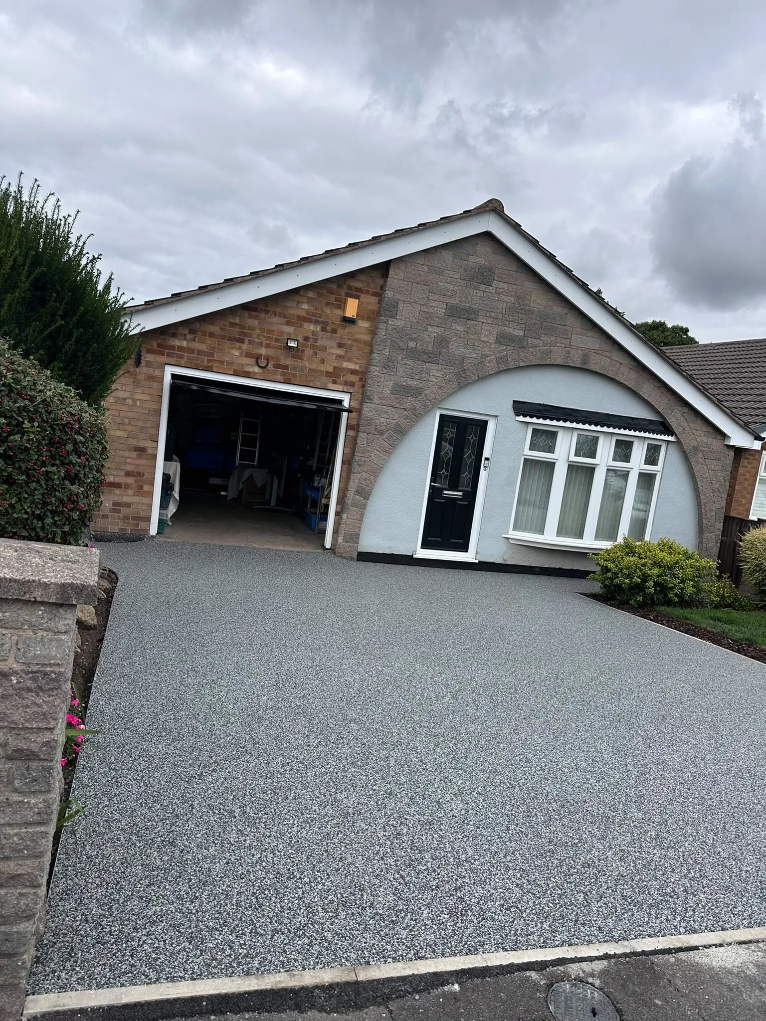 Finished grey resin bound driveway in front of a Skegby bungalow with the new kerb crossing at the road