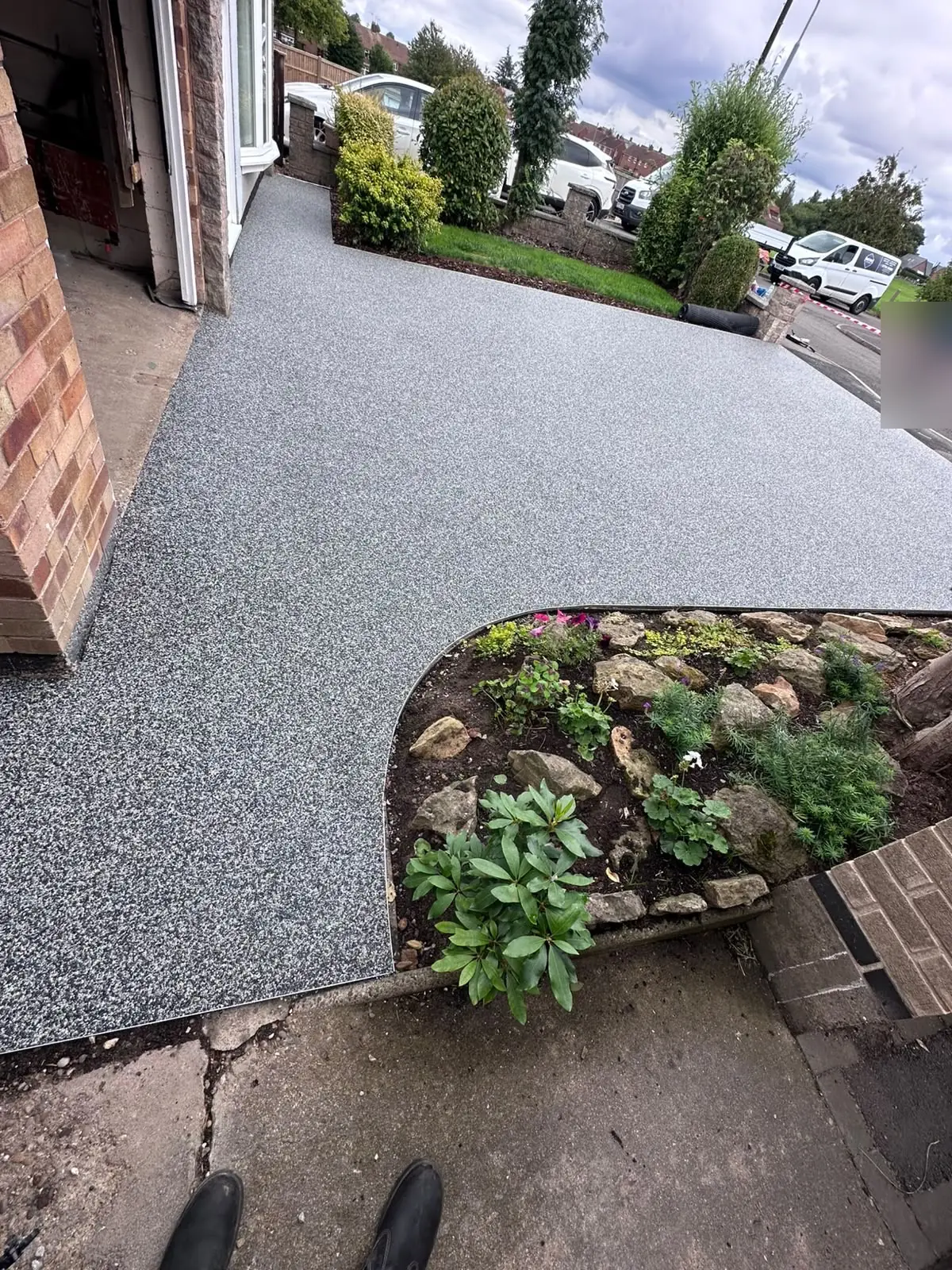 Grey and white resin being laid around a rockery bed on a Skegby driveway