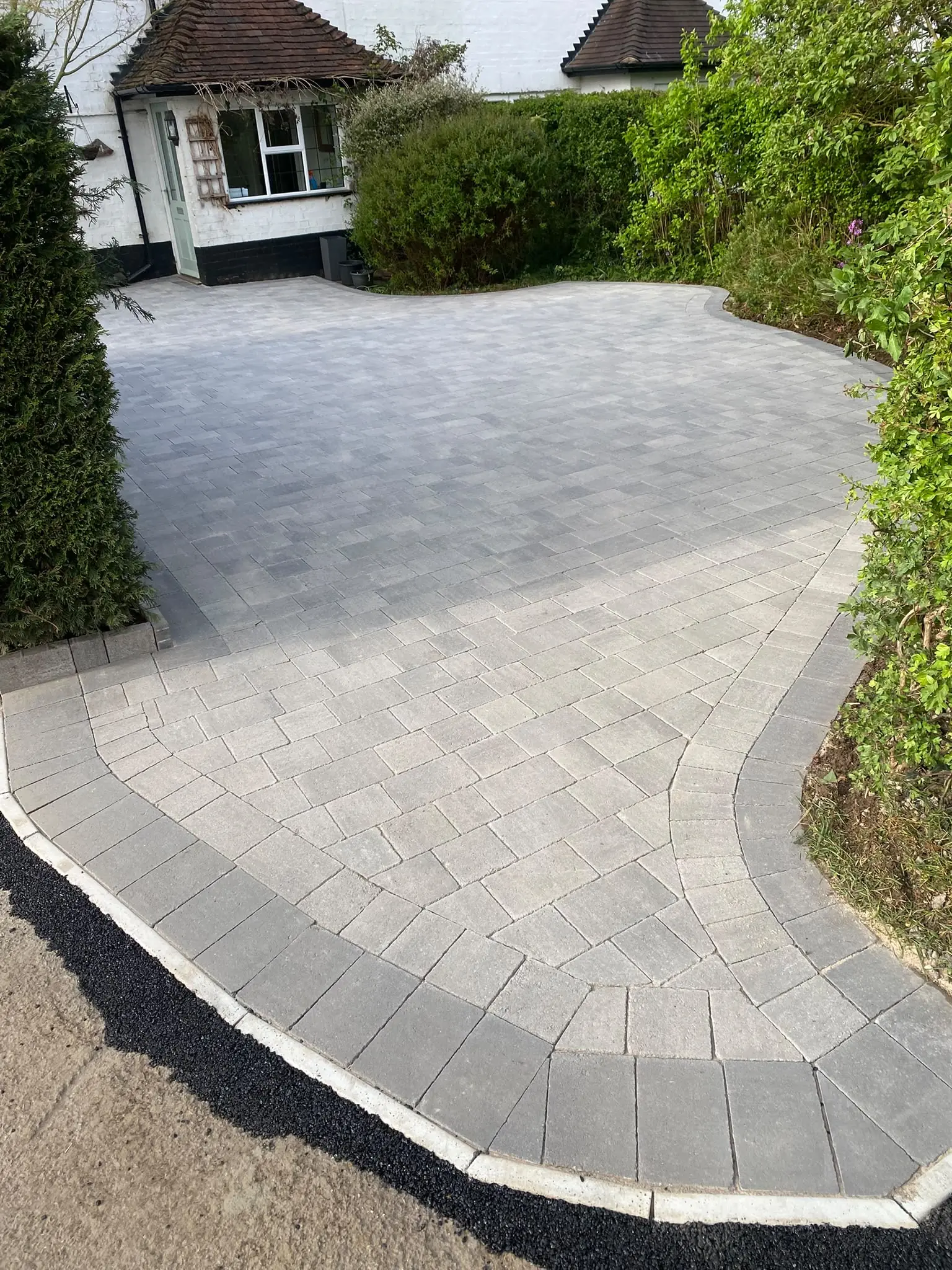 Light grey block paving with a curved grey border