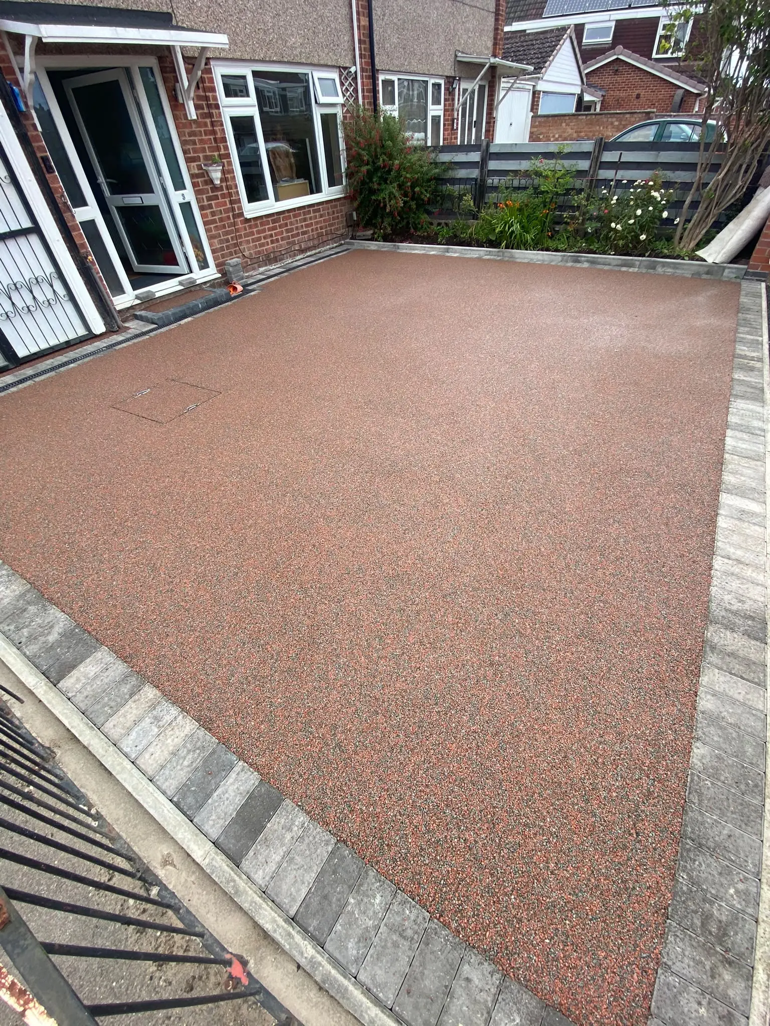 Red resin bound driveway with a stone-effect block border