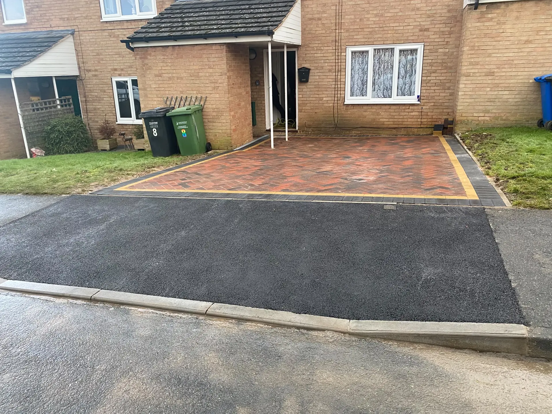 New tarmac crossing and a red block-paved drive with a yellow edge line